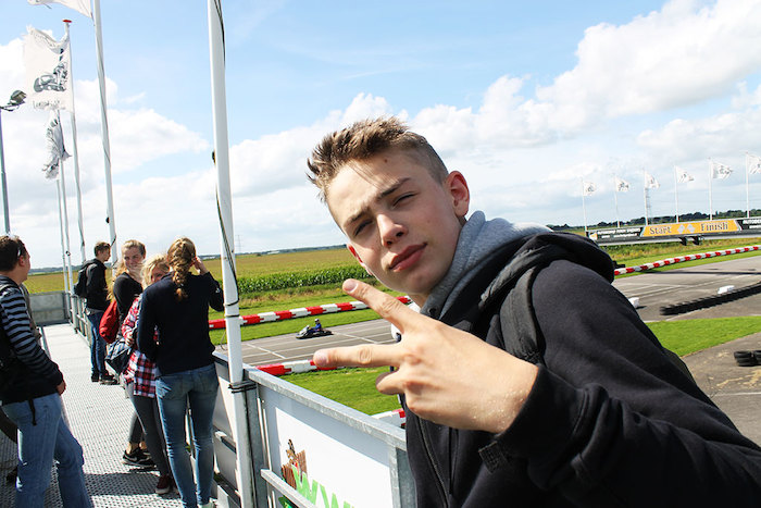 Een jongen poseert op de karting baan tijdens het avonturenkamp in Drenthe