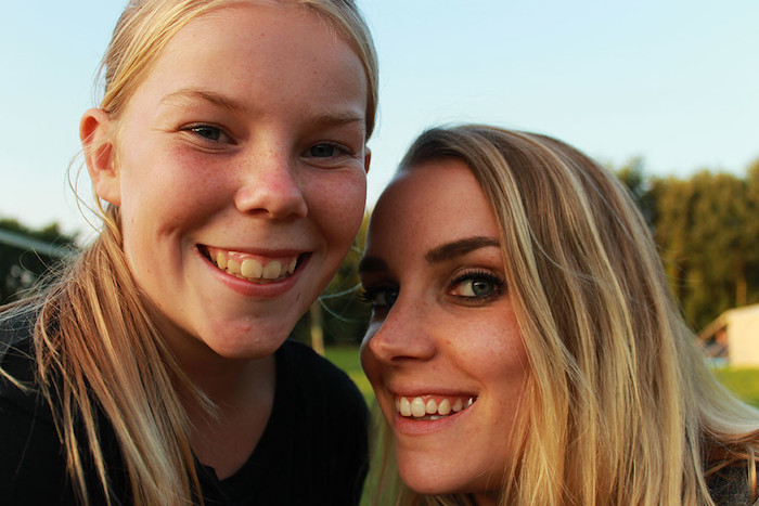 Close-up van twee tienermeisjes die lachen naar de camera tijdens hun jeugdkamp.