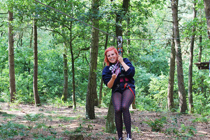 Een meisje glijdt van de zipline tijdens het avonturenkamp in Drenthe