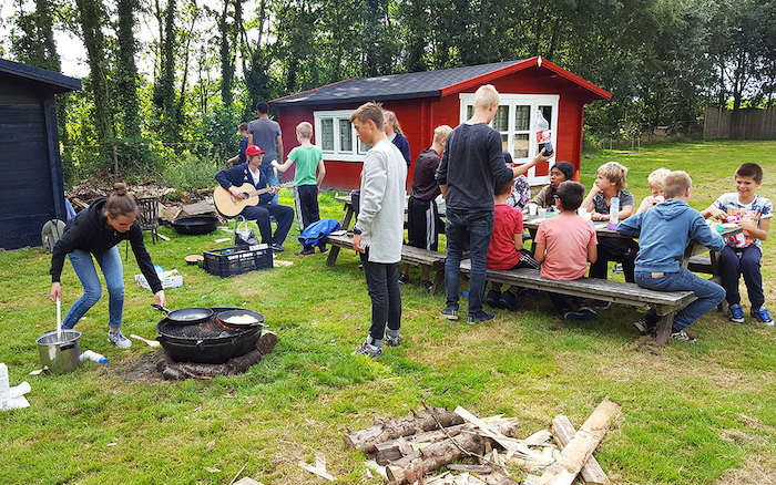 Kinderen tijdens de lunch op het survivalkamp in Drenthe.