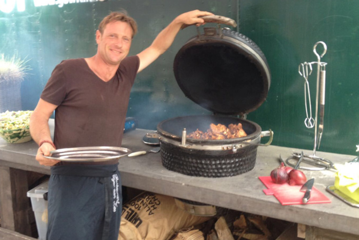 Begeleider op jeugdkamp opent pot met eten.