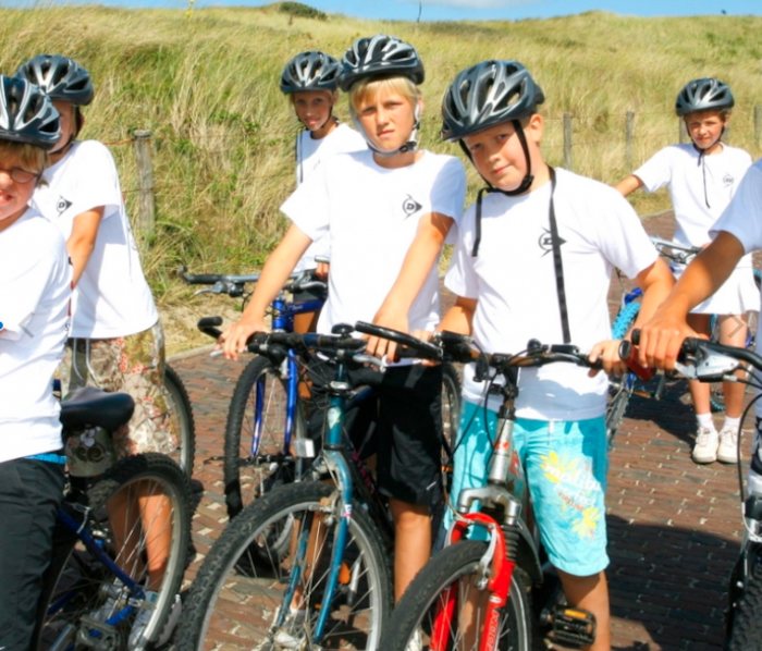 Jongens poseren met fietsen en helmen.
