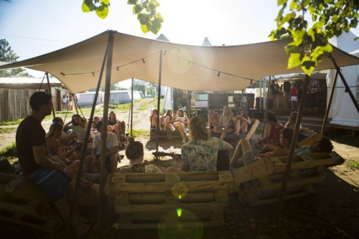 jongeren chillen onder tent in de zon op surfkamp spanje