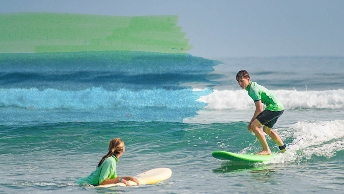 jongen en meisje surfen op het water op surfkamp
