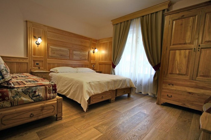 Zicht op houten kamer met bed, lakens tijdens wintersportkamp