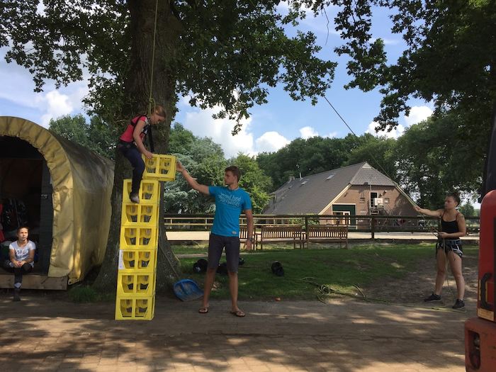Jongens stapelen gele bakken op survival in Overijssel op zomerkamp nederland