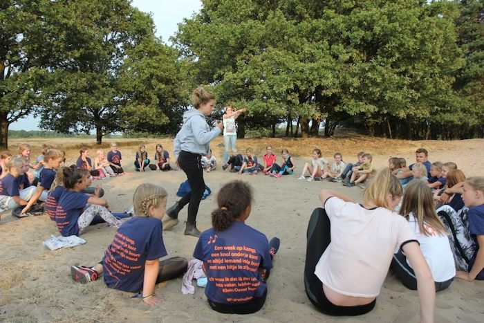 Kinderen spelen kringspel op survivalkamp in Overijssel op zomerkamp nederland