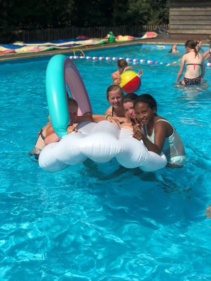 Meisjes in mooi blauw zwembad poseren voor de camera op zomerkamp nederland