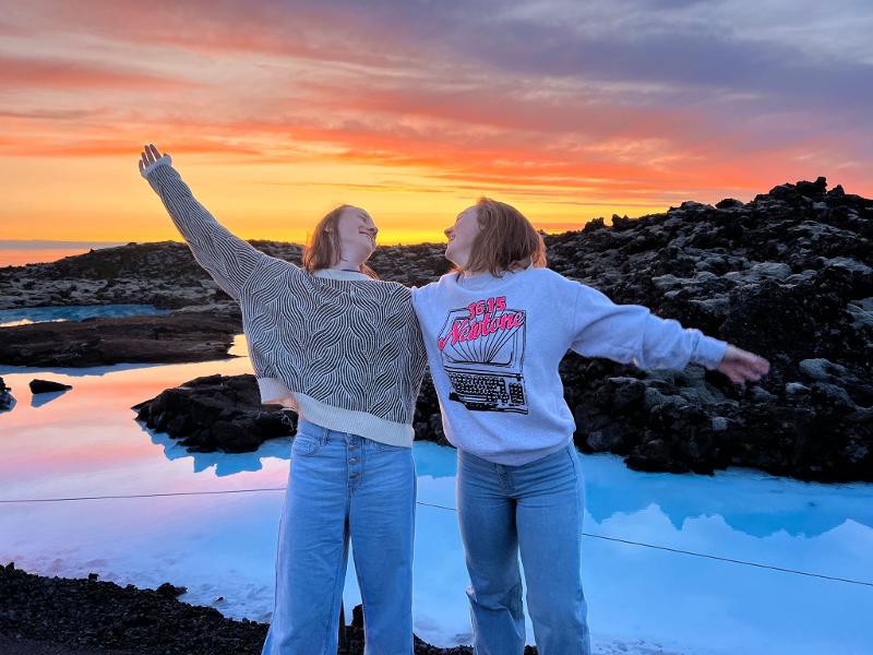 Een foto van een zonsondergang met deelnemers van een groepsreis Ijsland