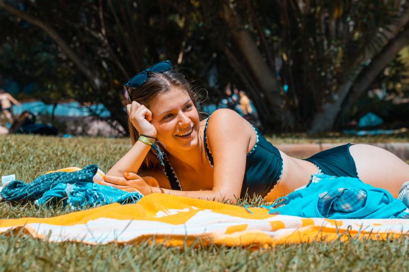 Meisje ligt op badhanddoek tijdens haar jongerenreis in Calella