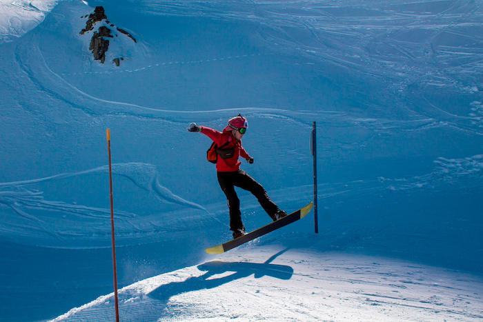Meisje springt met snowboard op winterkamp