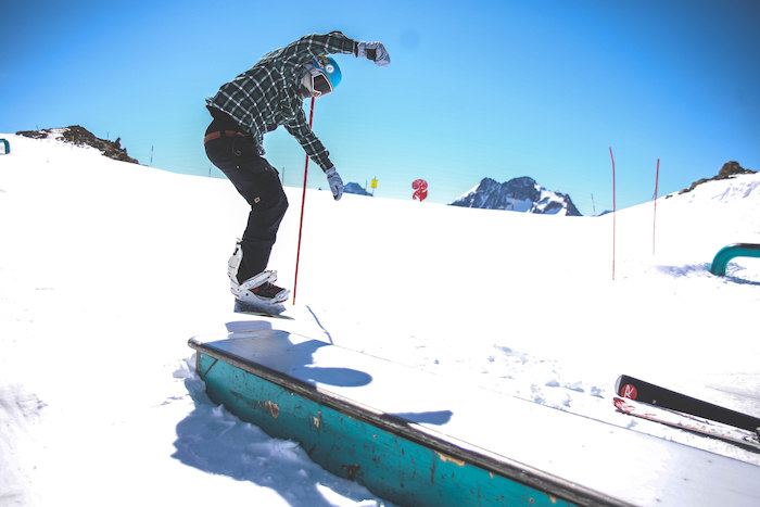 Jongen springt met snowboard op winterkamp