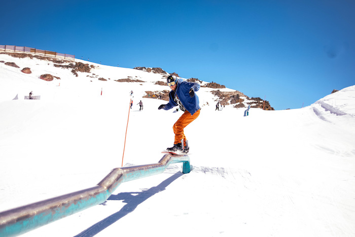 Rail trick op winterkamp met snowboard