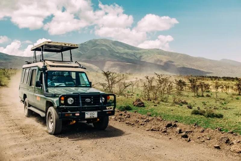 Een auto staat voor een berg tijdens een groepsreis in Afrika