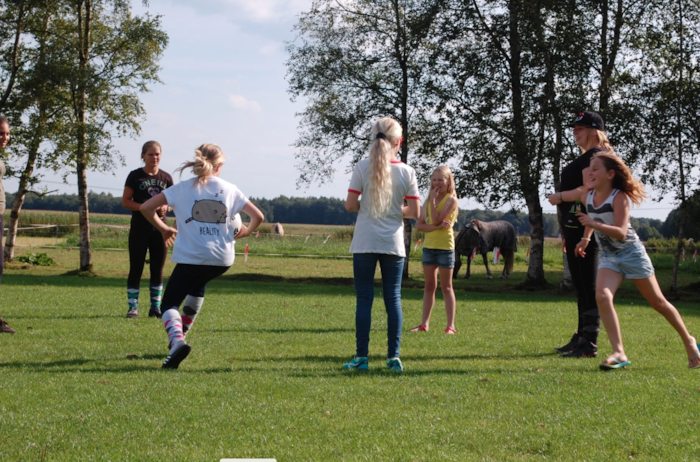 Kinderen spelen spel op theaterkamp in grasveld.