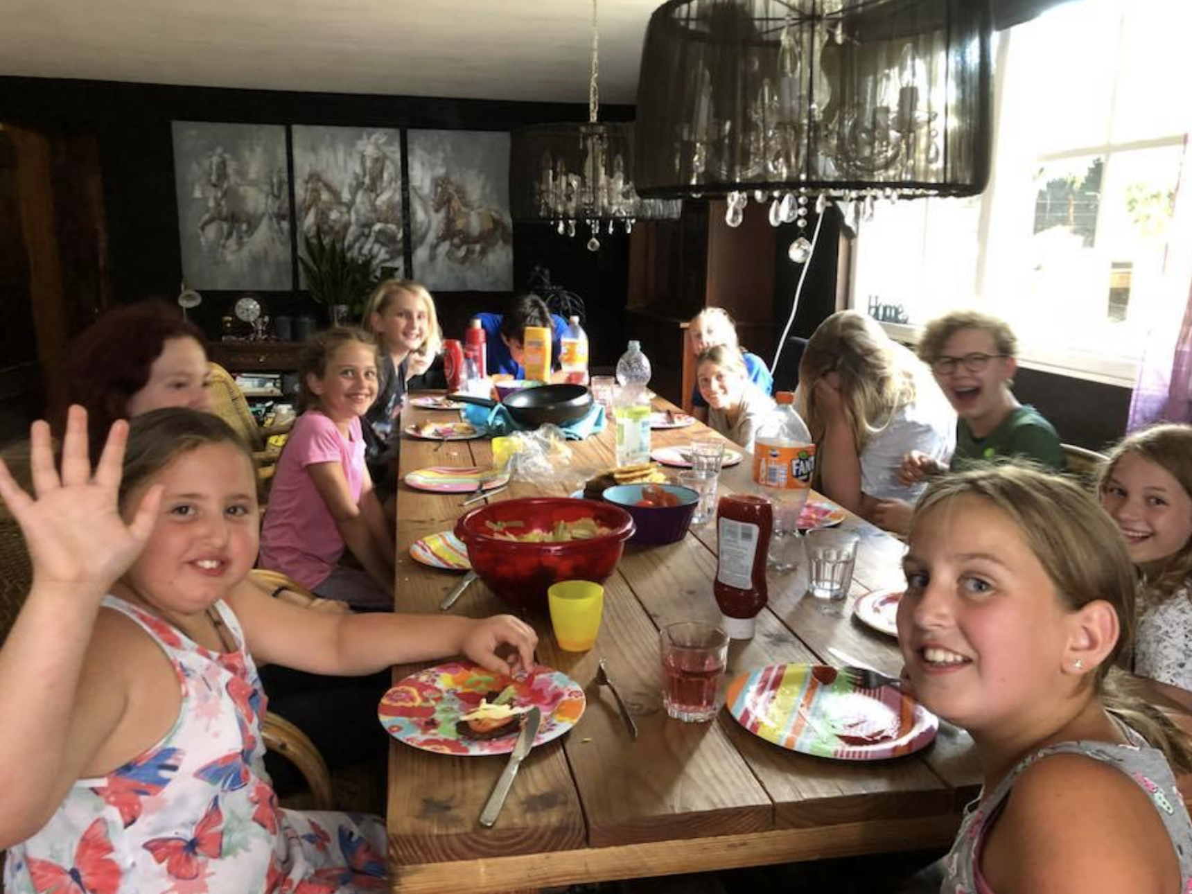 un grupo de niños en una mesa comiendo el desayuno en un campamento de cine para niños