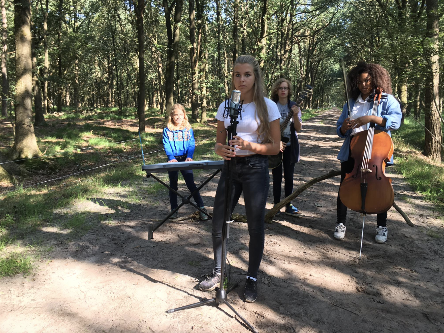 Meiden tijdens summer camp spelen muziek in een bos
