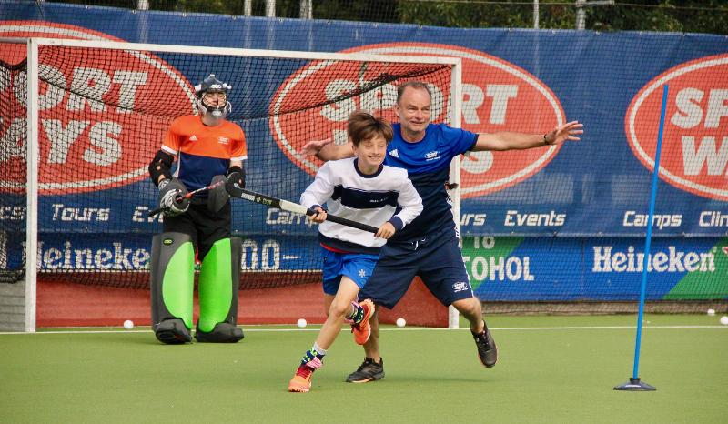 Jongen staat samen met trainer voor het doel 