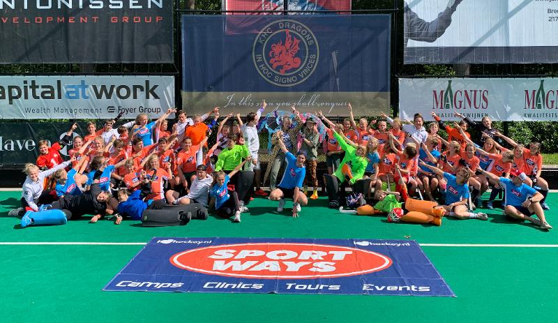 grote groepsfoto waarbij iedereen wijst naar het logo op hockeykamp antwerpen