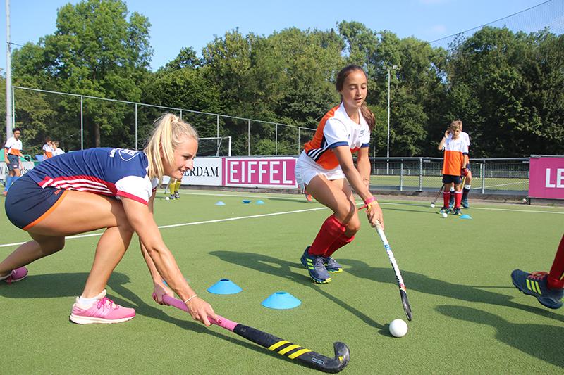 meisjes doen hockey oefening samen op zomerkamp antwerpen hockeykamp