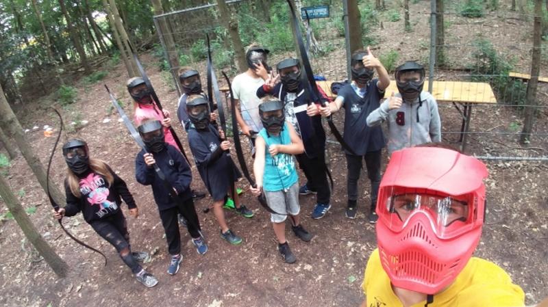 Jongens met maskers poseren voor de camera bij het boogschieten.
