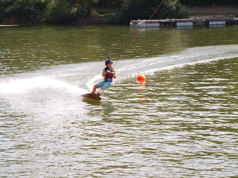Jongen raast over het water op zomerkamp in Zeeland.