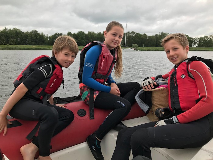 Kinderen zitten in boot op zeilkamp Haarlem