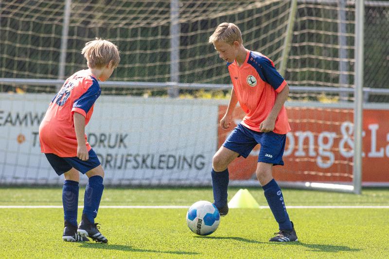 twee jongens in duel op het veld op voetbalkamp overijssel