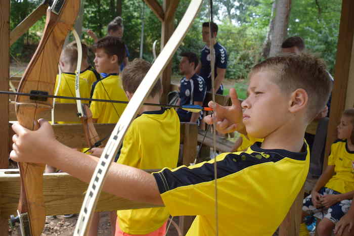Jongens boogschieten op voetbalkamp in Overijssel.