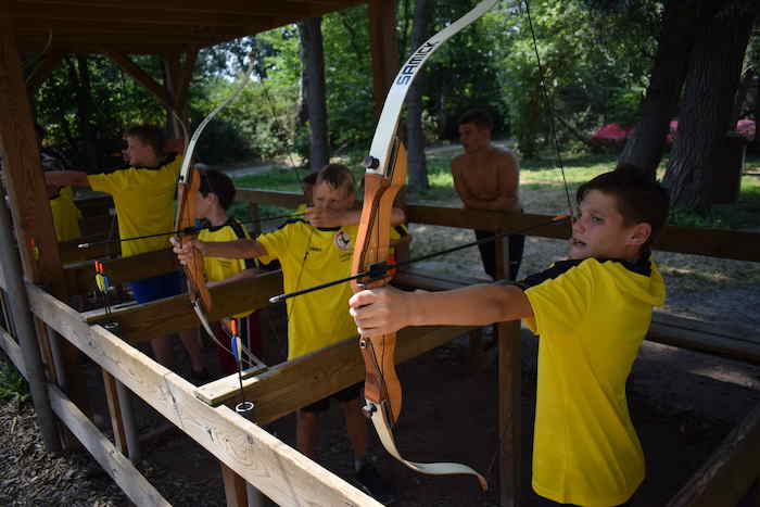 Jongens tijdens het boogschieten op voetbalkamp.