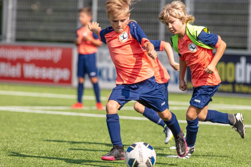 jongens in duel tijdens het voetballen op voetbalkamp overijssel