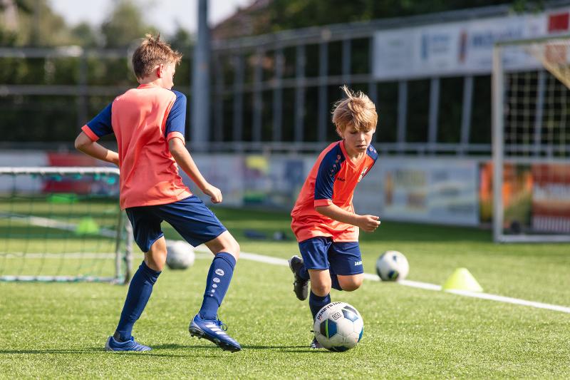 twee jongens aan het voetballen op voetbalkamp overijssel