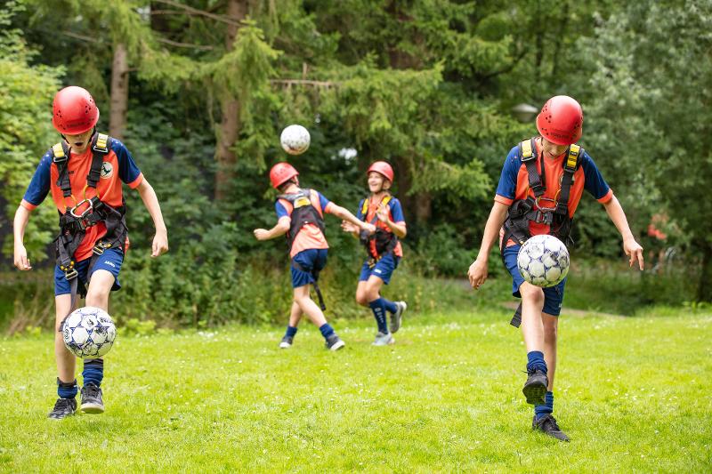 jongens in klimgear houden bal hoog op voetbalkamp overijssel