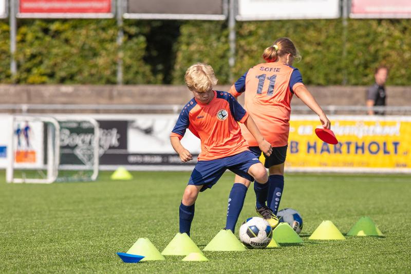 jongen en meisje doen voetbal oefening op voetbalkamp overijssel