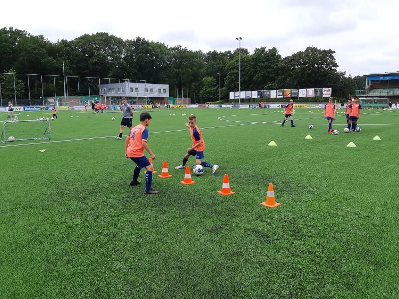 jongens krijgen voetbaltraining op het veld op voetbalkamp overijssel
