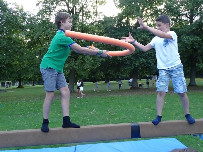 twee jongens spelen een evenwichtsspel op jeugdvakantie