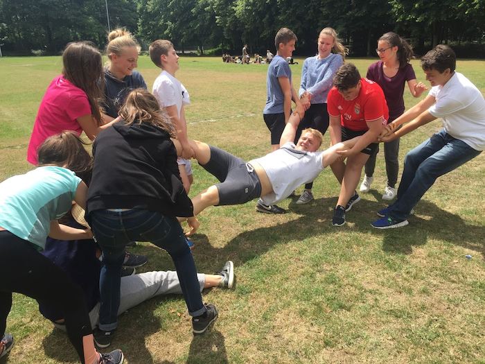jongen wordt in de lucht getild op jeugdvakantie