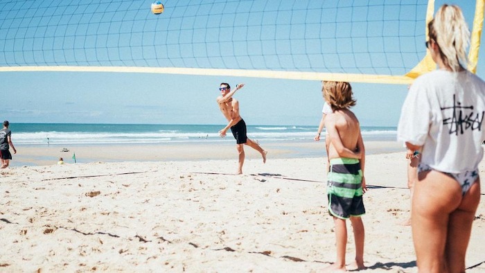 Jongeren spelen strandvolleybal op surfkamp jongeren