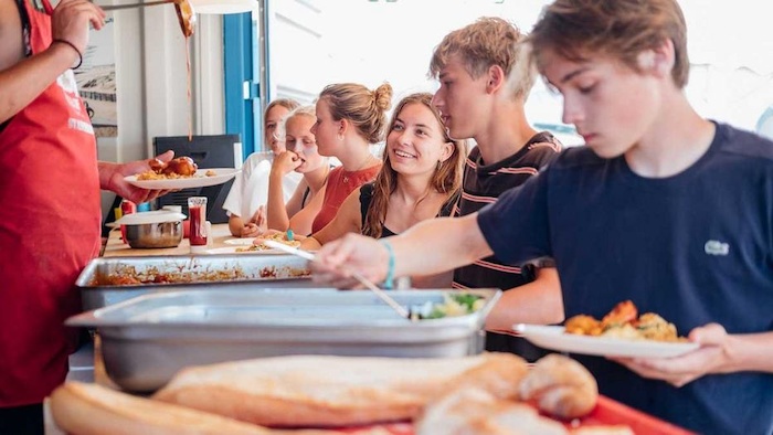 Jongeren eten samen tijdens surfkamp Frankrijk 15 jaar