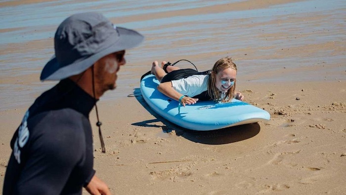 Meisje leert golfsurfen in Frankrijk van instructeur.
