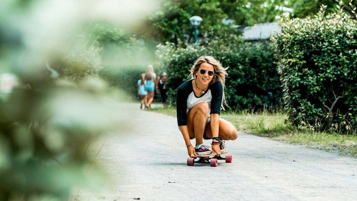 meisje is aan het longboarden op de straat op surfkamp jeugd in frankrijk