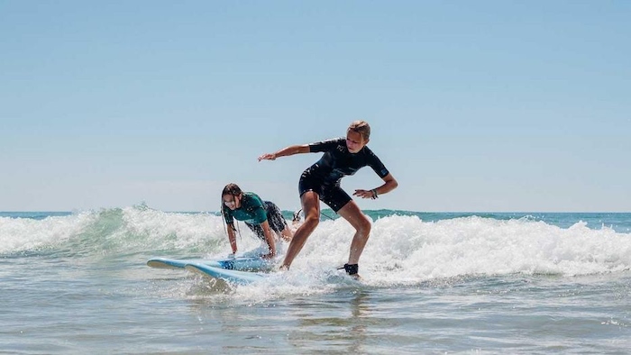 Twee meiden aan het golfsurfen in Frankrijk.