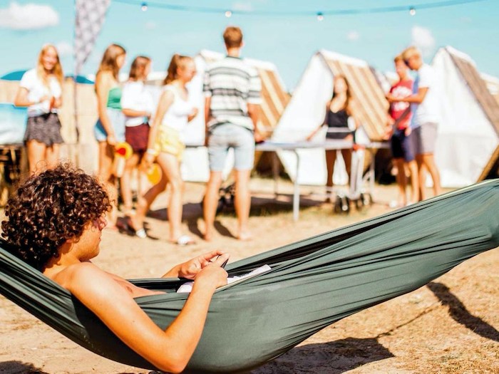 Jongen op kamp ligt in hangmat 