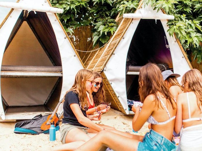 Meisjes zitten en spelen kaart op surfkamp Frankrijk