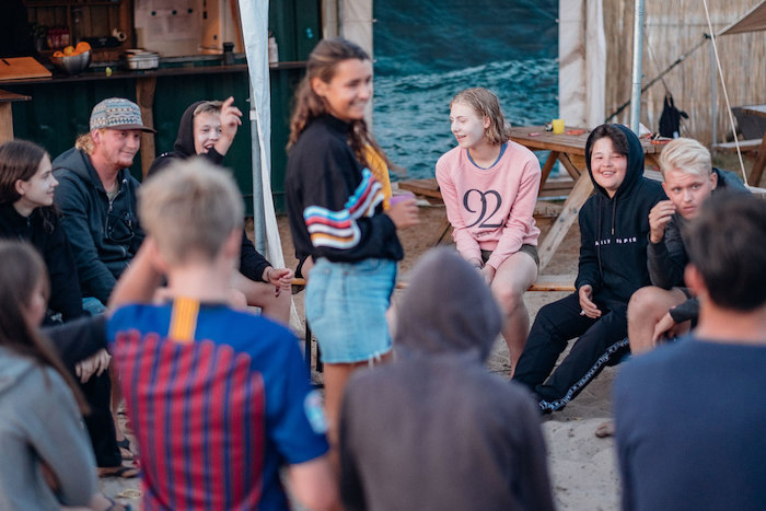 meisje staat in de kring terwijl jongeren praten op surfkamp voor jongeren in frankrijk