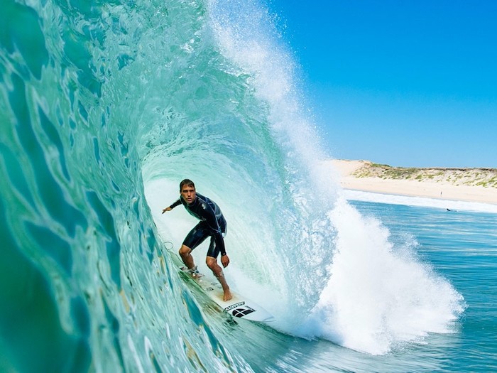 Een surfer in het water tijdens een groepsreis Frankrijk