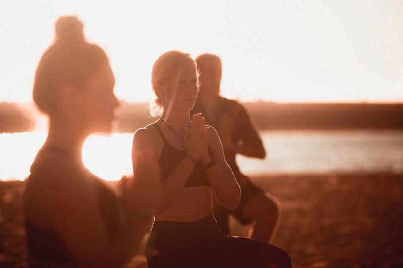 Deelnemers van een studentenreis doen mee aan yoga op het strand