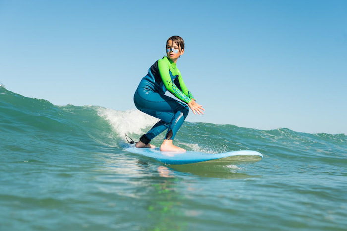Deelnemer van surfkamp Scheveningen is aan het surfen