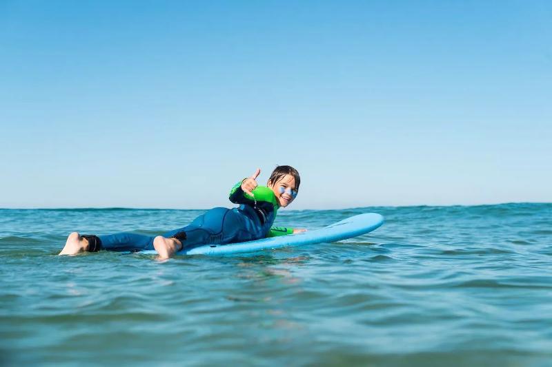 een jongen is aan het surfen tijdens een surfkamp Spanje 15 jaar