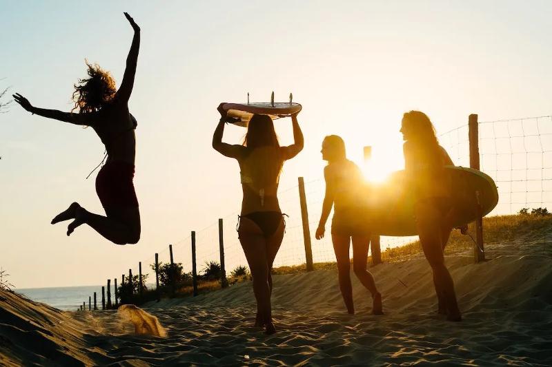 meisjes lopen naar de zee tijdens een surfkamp Spanje 15 jaar
